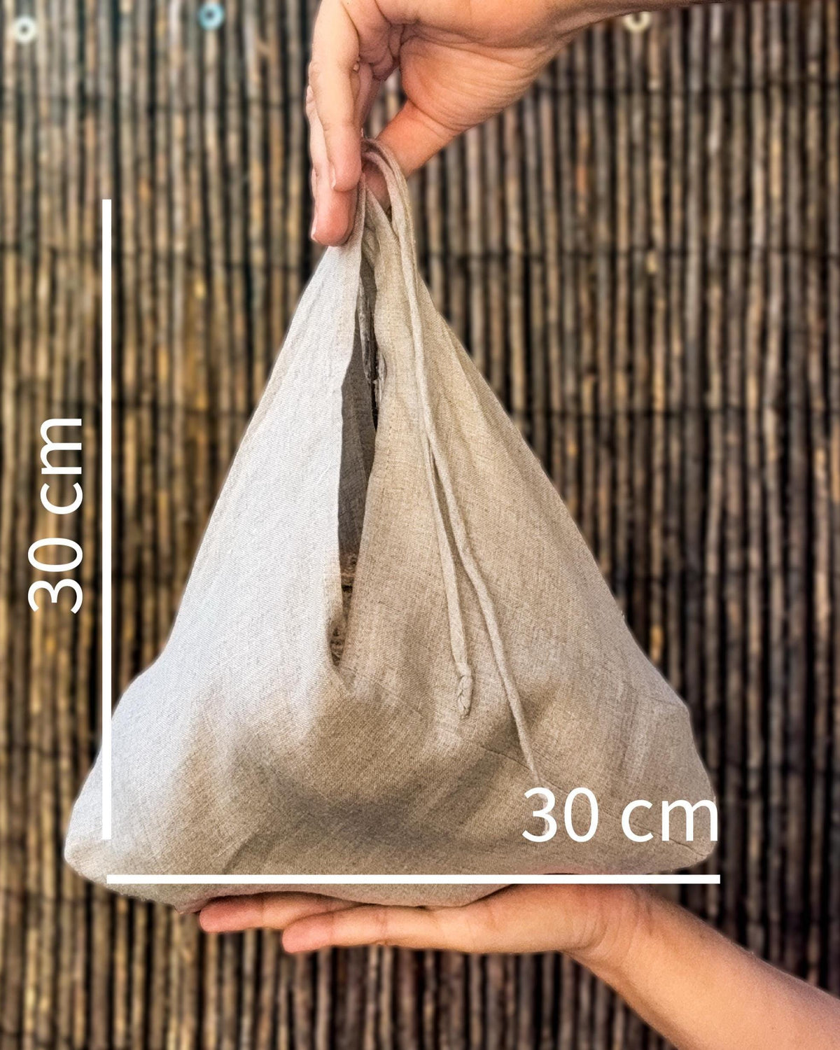 Hand holding a linen bread bag, 30 × 30 cm size