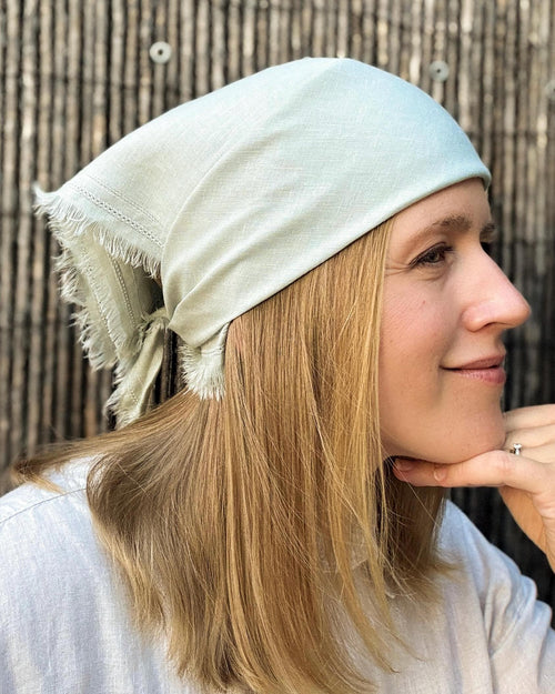 Woman wearing a pale mint linen bandana tied at the back