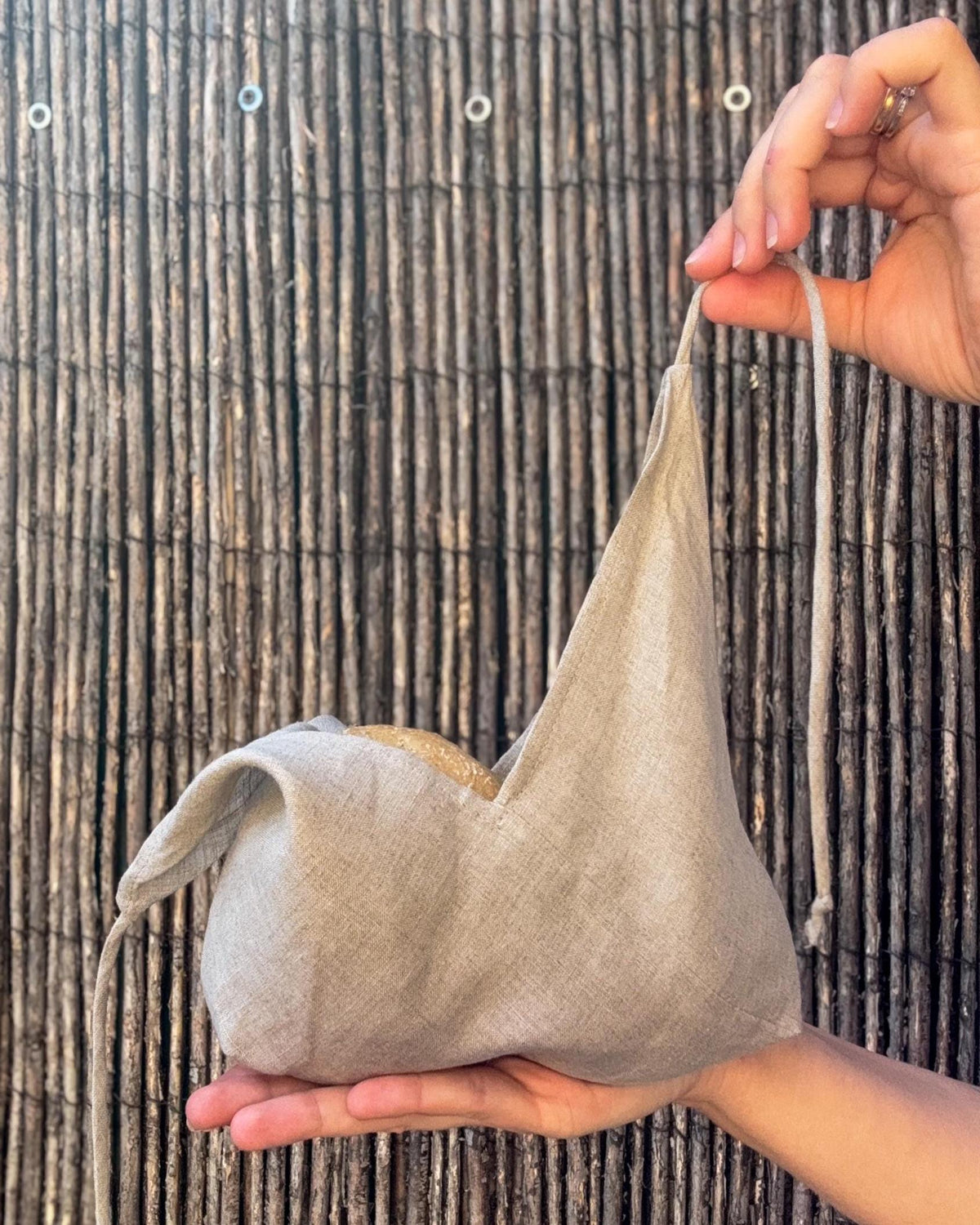 Filled linen bread bag folded in the hand