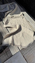 Linen table runner draped over dark wooden boards