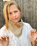 Embroidered linen bandana tied at the neck as a kerchief