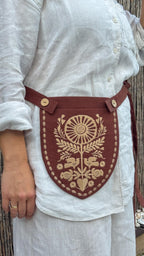 Rust belt pouch worn at the waist, side view