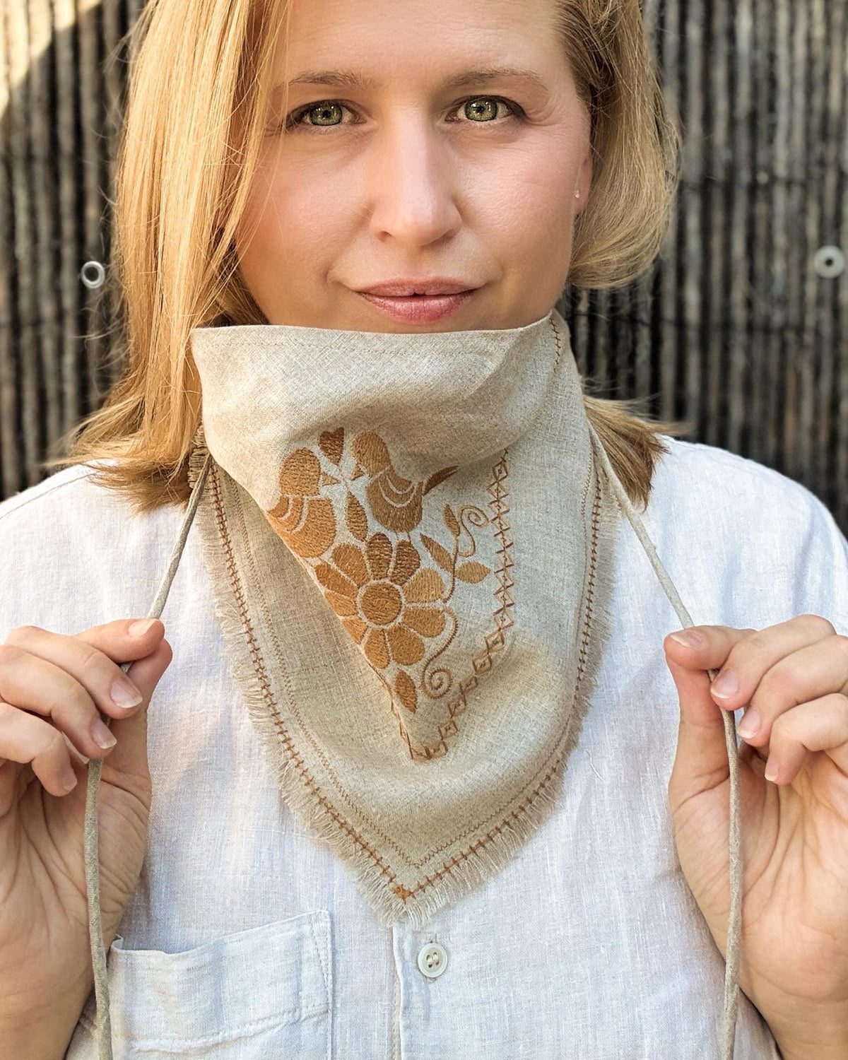 Woman holding the ties of an embroidered linen neckerchief