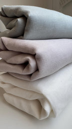 Stack of folded linen squares in grey and cream