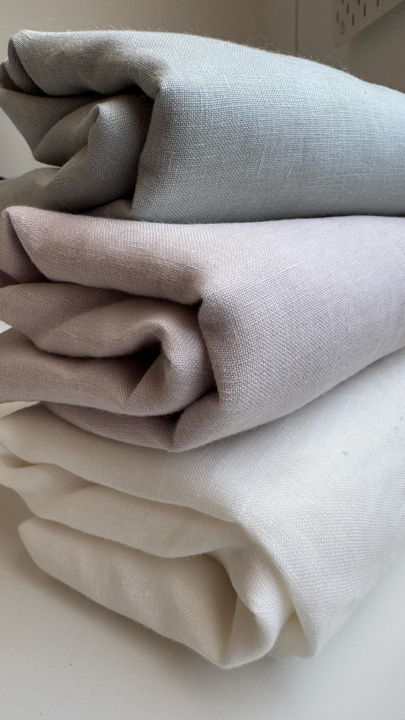 Stack of folded linen squares in grey and cream